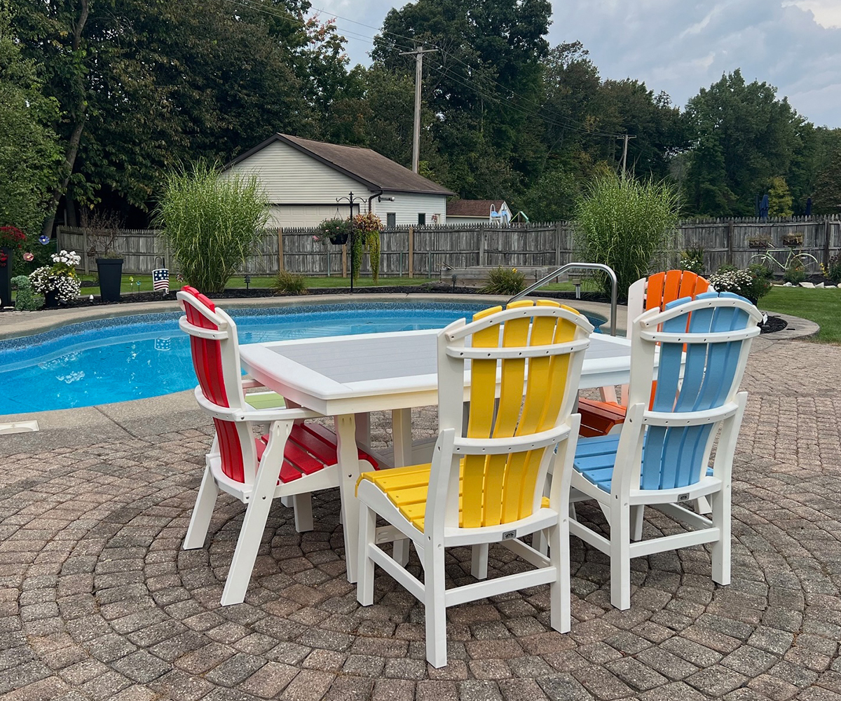 Poly vs. Wood Outdoor Furniture: Which Should You Choose? 1 Colorful poly outdoor dining set beside a backyard pool